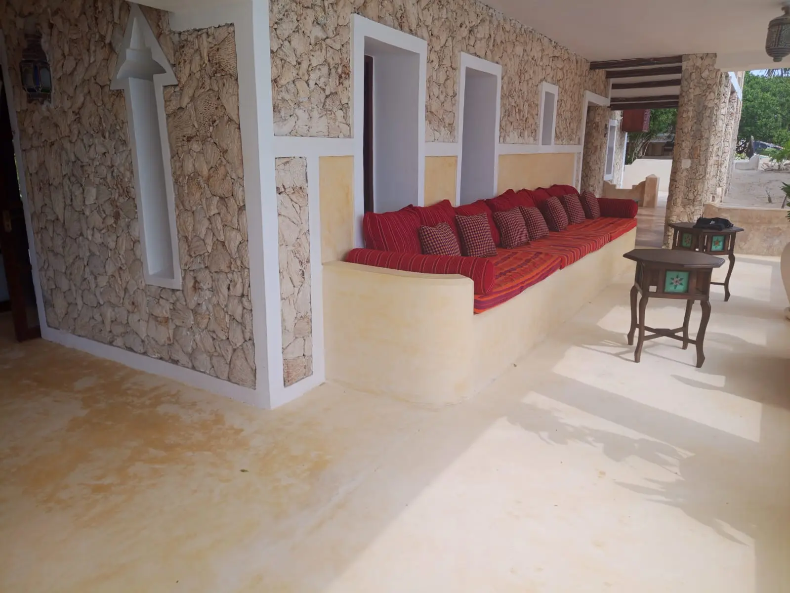Built-in seating area with coral stone walls and red cushions