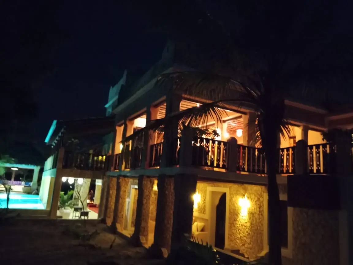Main house exterior at night with traditional Swahili architecture